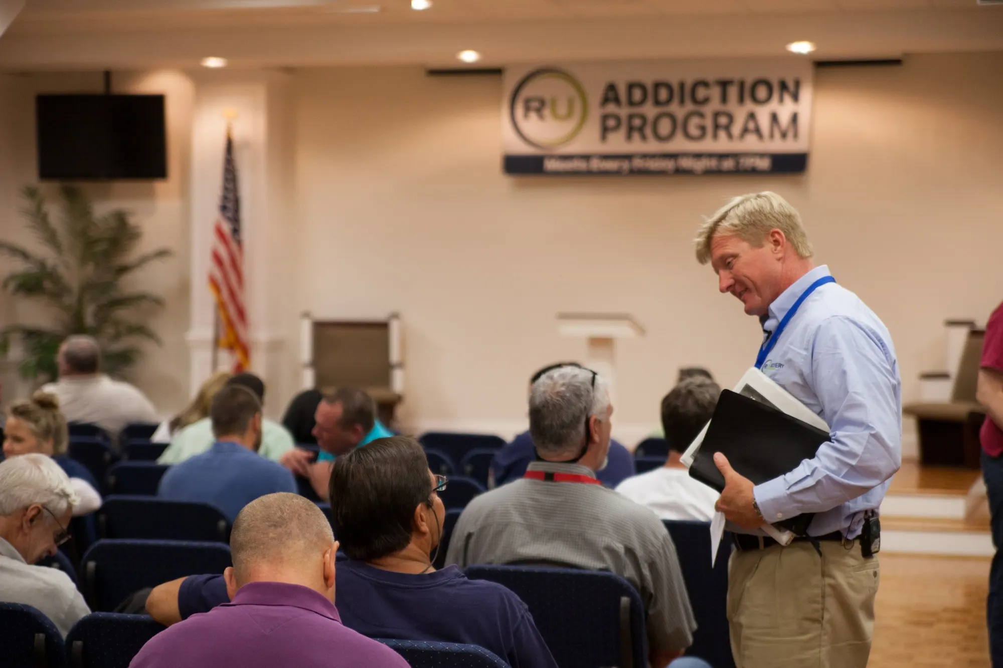 An RU leader talking with participants at a recovery meeting
